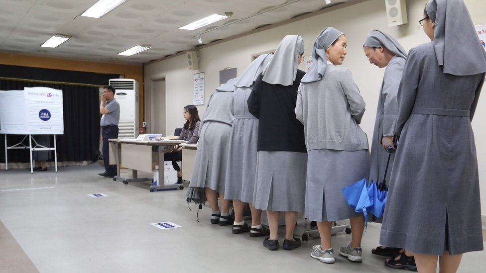 Nuns wait to vote at a polling station in South Korea