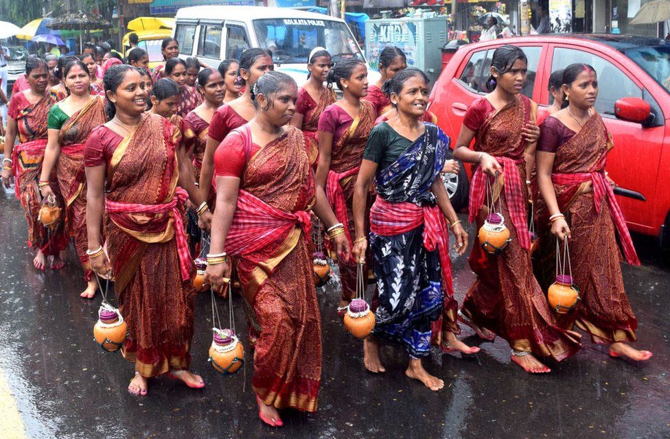 Despite heavy rain, men and women Kanwariyas march to a Shiva temple in Kolkata to offer the holy water from the Ganges.