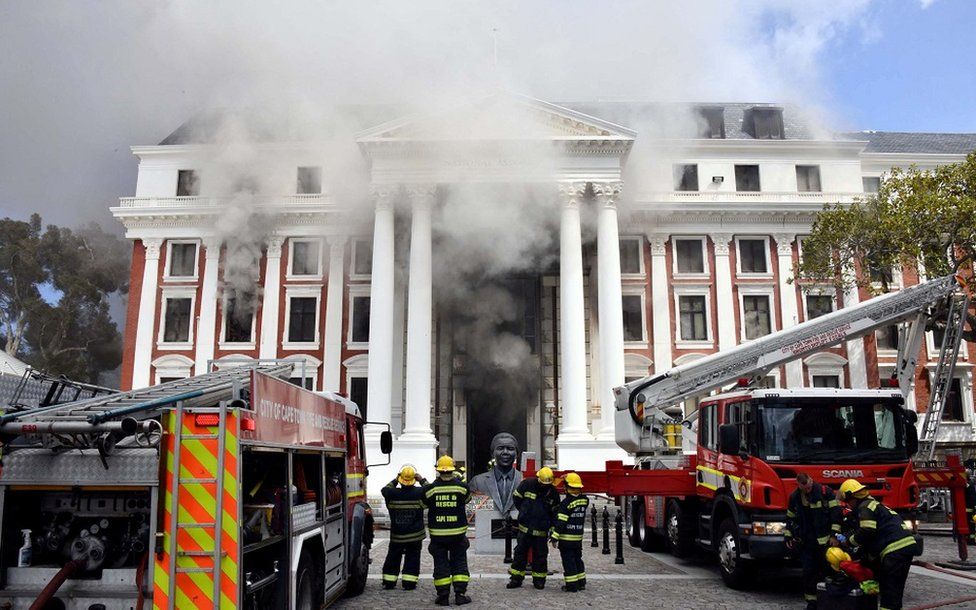 Пожарные работают после возникновения пожара в здании парламента в Кейптауне, ЮАР, 2 января 2022 г.
