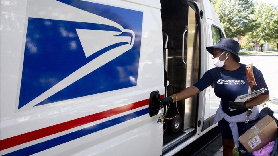 A postal workers closes a truck door