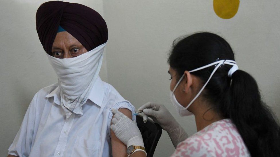 Медицинский работник делает мужчине дозу вакцины против коронавируса Covid-19 в больнице в Амритсаре 30 марта 2021 г.