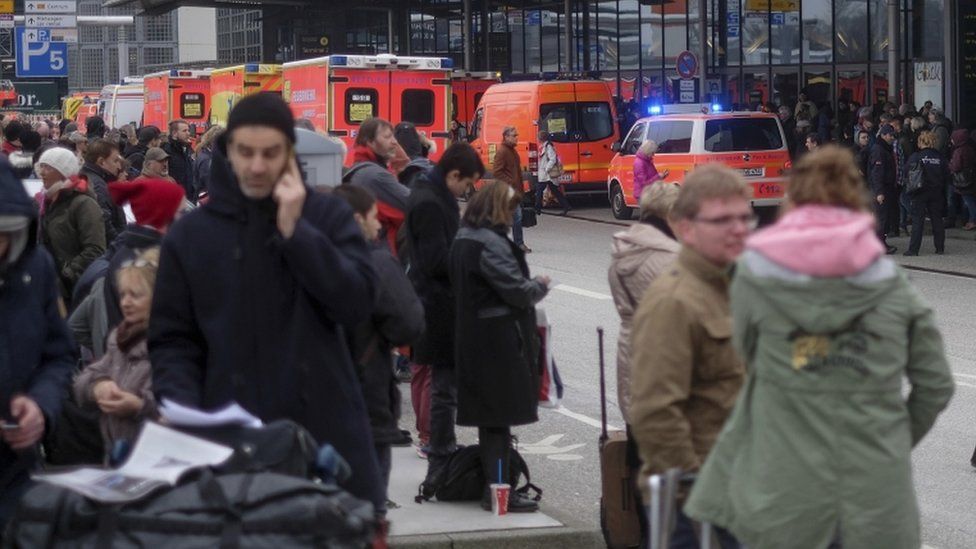 Travellers wait outside the Hamburg, northern Germany, airport Sunday, 12 February 2017 after after several people were injured by an unknown toxic that likely spread through the airport's air conditioning system