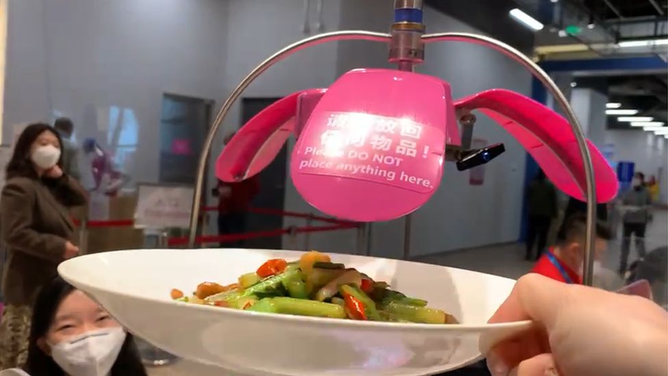 A dish is taken off a meal-delivery machine
