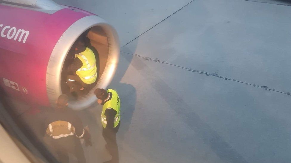 Airline staff check the plane's engine
