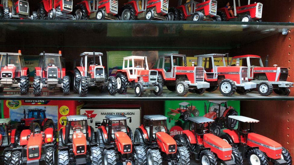 Models of red Massey Ferguson tractors sitting on shelves
