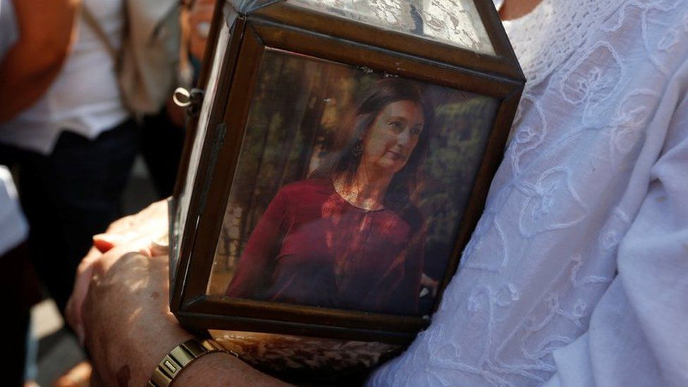 A woman holds a lantern with a picture of investigative journalist Daphne Caruana Galizia, who was assassinated in a car bomb attack, during a protest outside the law courts in Valletta, Malta, October 17 2017