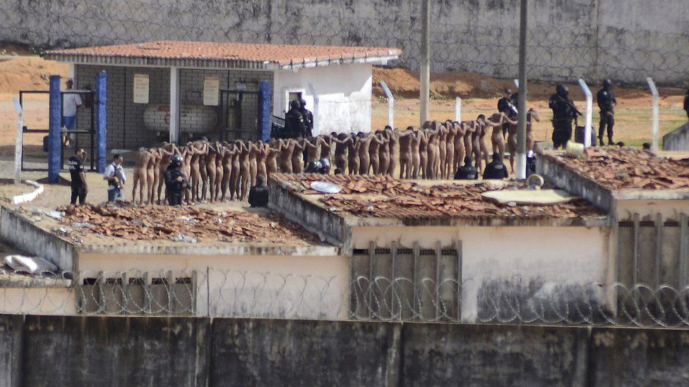 Naked inmates stand in line while surrounded by police after a riot at the Alcacuz prison in Nisia Floresta, Rio Grande do Norte state, Brazil,