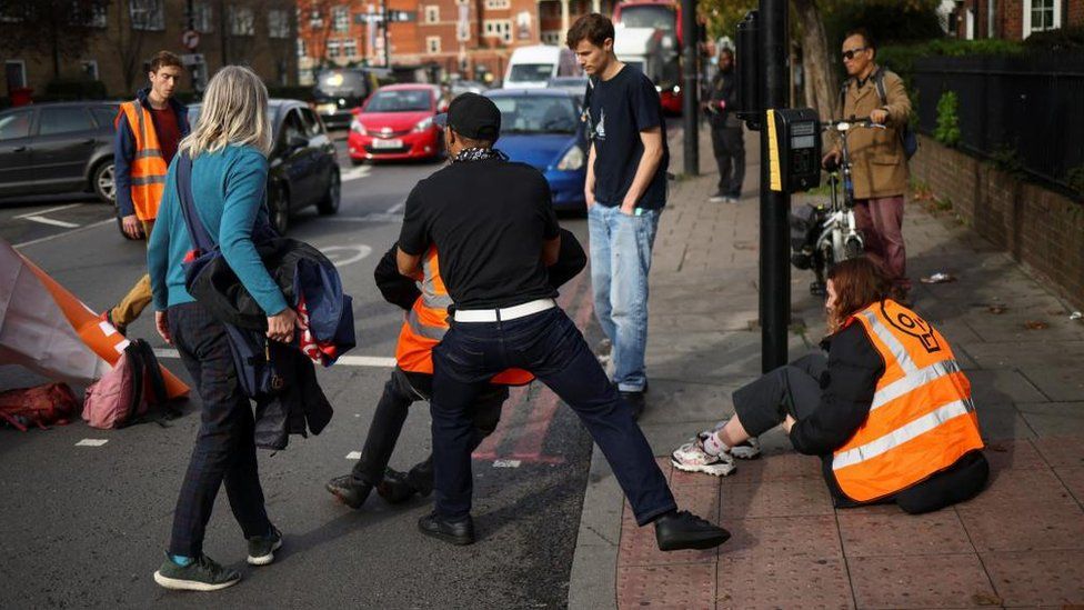 Members of the public remove activists from a road during a Just Stop Oil protest in London