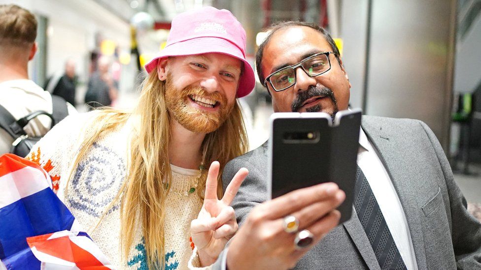 Sam Ryder (left) having a selfie taken after arriving back at Heathrow Airport on Sunday