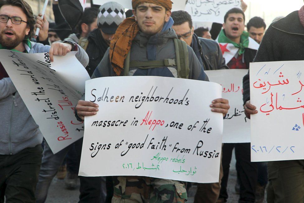 Protesters carry signs during a demonstration in Aleppo against Russian air strikes and an offensive by government forces (2 February 2016)