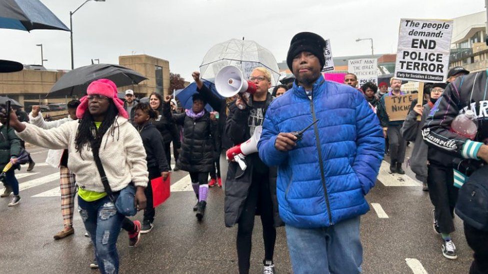 Protest organizer Casio Montez, in blue, leads a march in Memphis