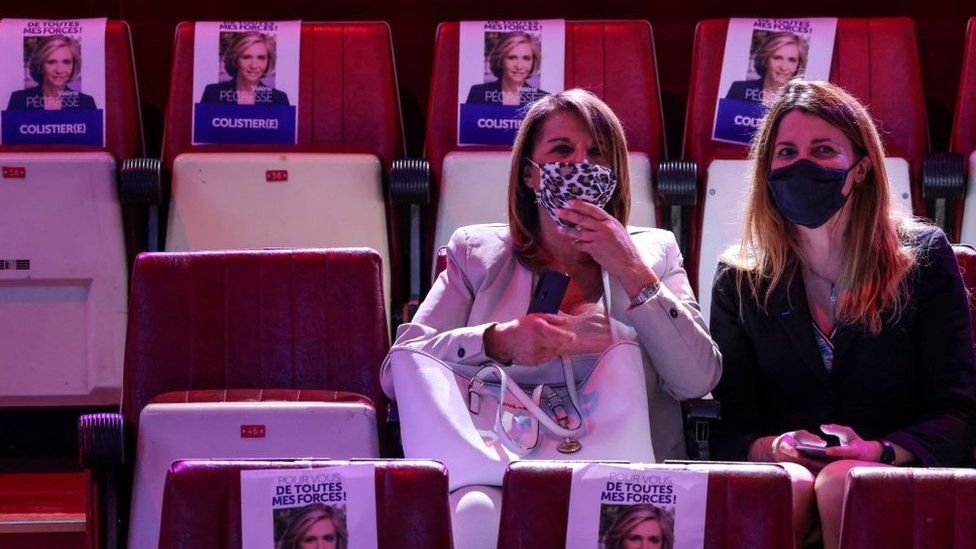 Supporters sit next to posters of Ile-de-France region's president and candidate for reelection Valery Pecresse during a campaign meeting at the Cirque d'Hiver in Paris on June 24, 2021,