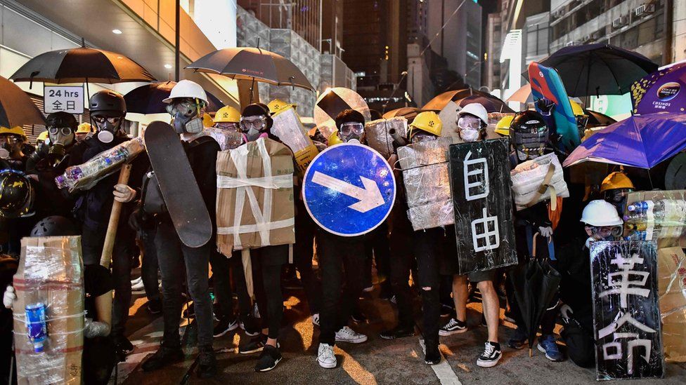 Protesters stand together with makeshift shields