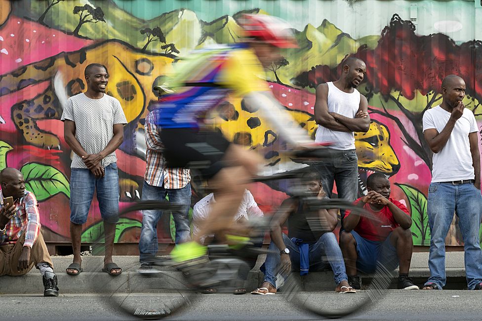 People watching a cyclist riding through Masiphumelele near Cape Town, South Africa - Sunday 8 March 2020