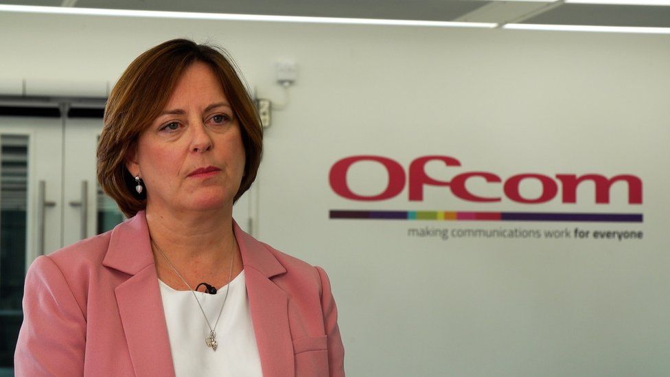 Dame Melanie Dawes, chief executive of Ofcom, stands beside Ofcom logo