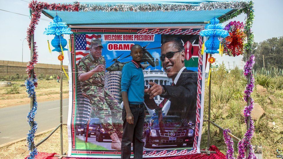 A Kenyan stands in front of a placard depicting US president Barack Obama as he waits for his arrival near a stadium in Nairobi 26 July 2015
