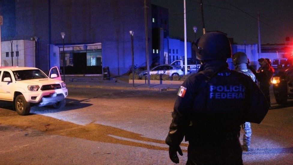 Federal police officers stand guard at the site of an attack on a police station in Villagrán, Guanajuato, Mexico, 11 December 2019