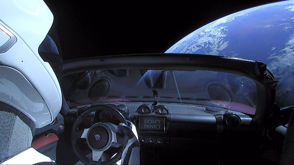 A sign on the dashboard reads "Don't Panic", a nod to the Hitchhiker's Guide to the Galaxy