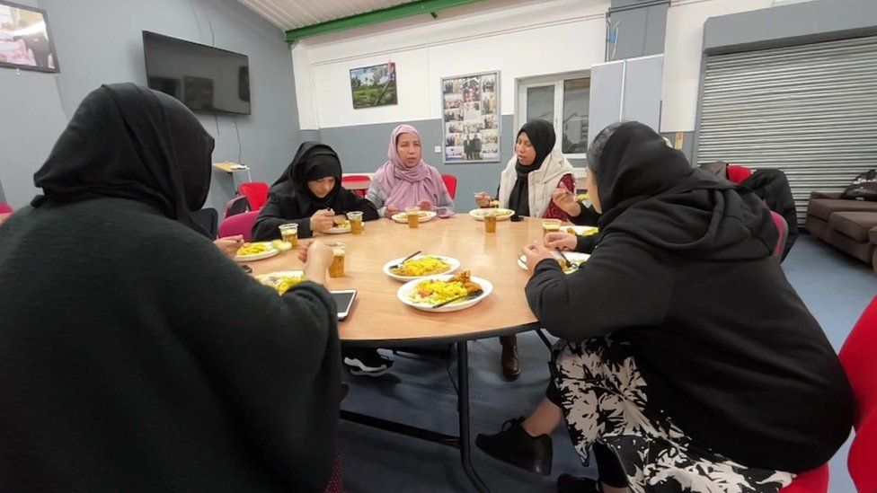 Women eat food at the Bangladeshi Youth Organisation