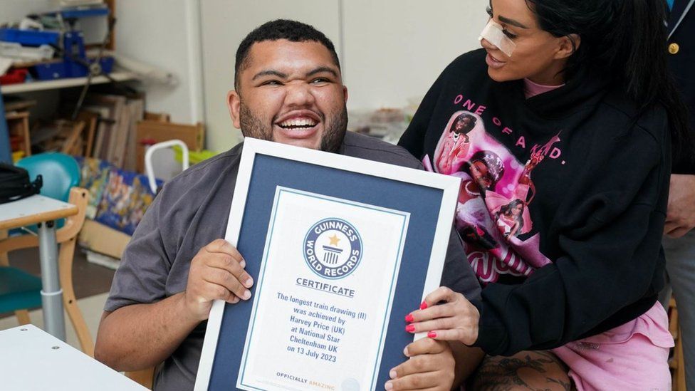 Katie Price and Harvey Price holding his Guinness World Record certificate