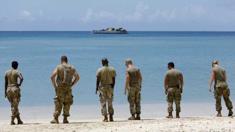 US soldiers wait on a beach for a navy landing craft as their unit evacuates in advance of Hurricane Maria, in Charlotte Amalie, St Thomas, US Virgin Islands. Photo: 17 September 2017