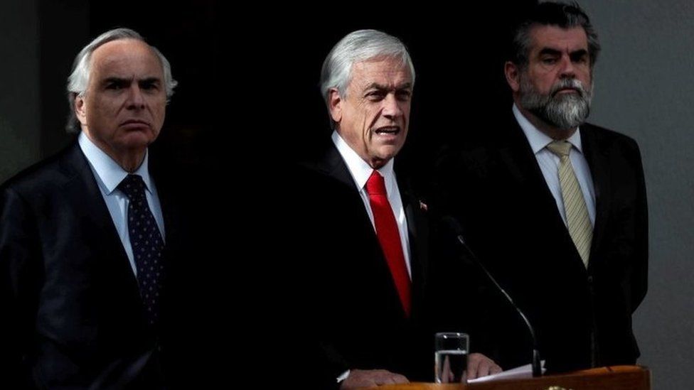 The president of Chile, Sebastian Pinera (C), speaks with the Minister of the Interior, , during a press conference in Santiago, Chile, 20 December 2018.