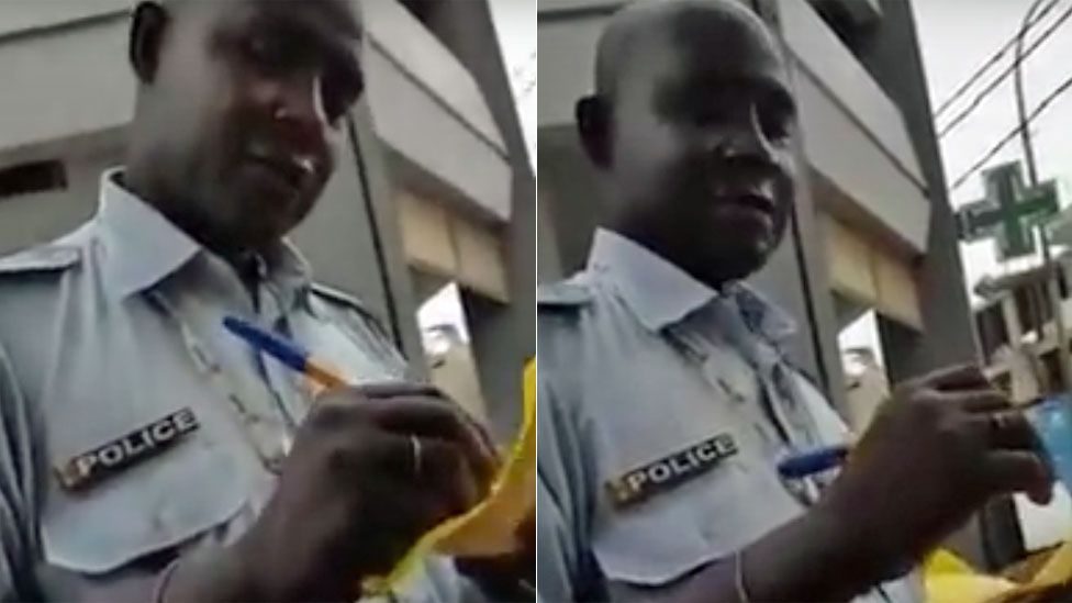A policeman in Senegal writing out a traffic ticket and accepting money