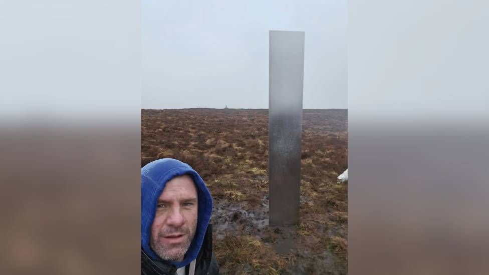 Builder Craig Muir with mysterious hilltop monolith in Powys