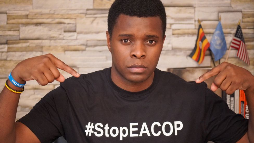 Hillary Innocent Taylor Seguya wears a black t-shirt with the hashtag #StopEACOP