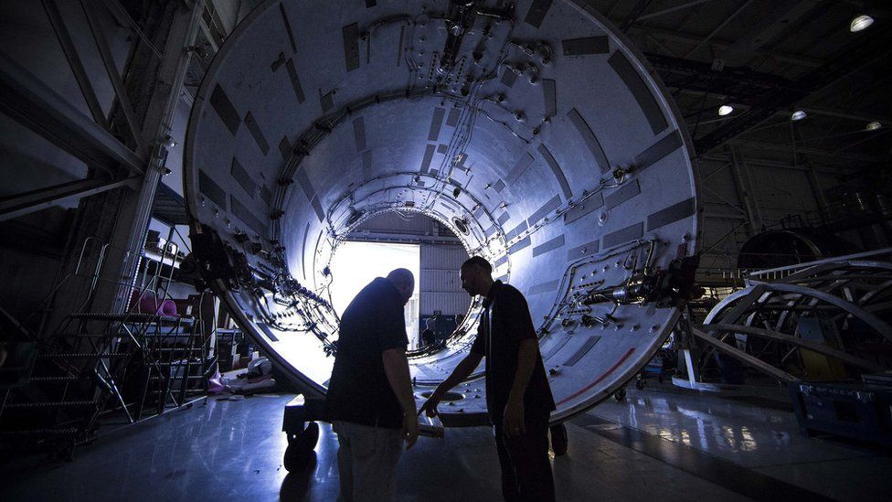 SpaceX technicians inspecting part of a Falcon 9 rocket