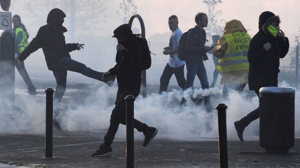French protesters run through tear gas in Quimper