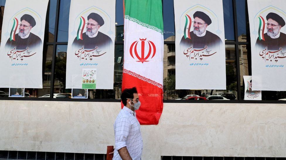 Мужчина проходит мимо иранского флага