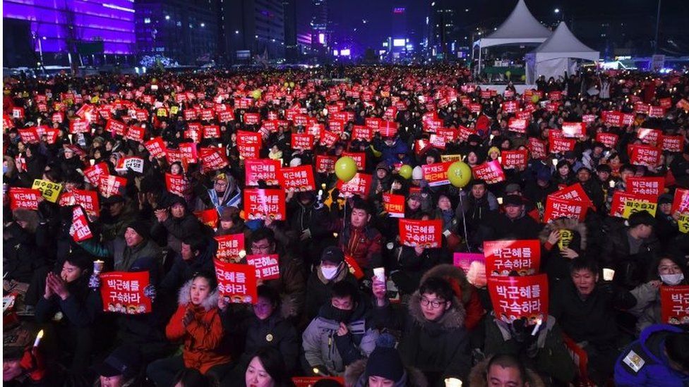 Protesters attend a candle-lit rally calling for South Korean President Park Geun-Hye"s immediate departure from her office, in downtown Seoul on 31 December