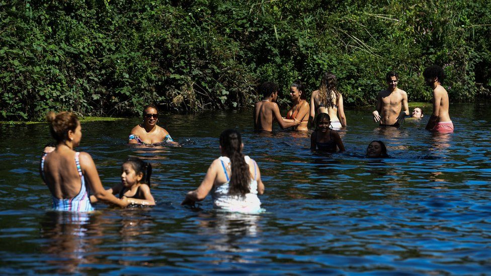 People enjoy the hot weather in the River Lea in east London