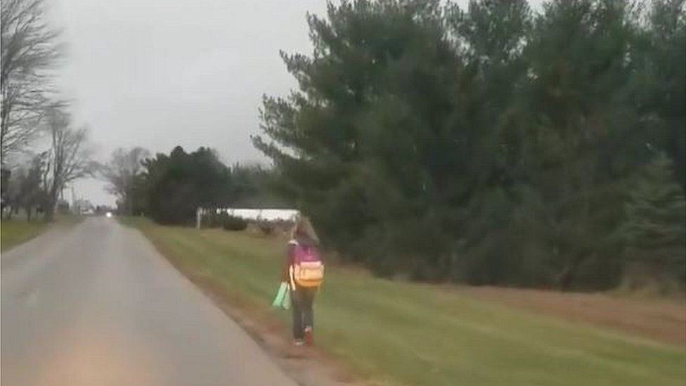 10 year old walking on road with backpack
