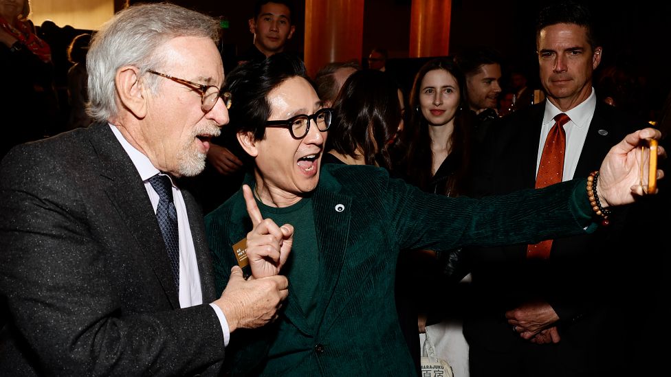 Steven Spielberg and Ke Huy Quan taking a selfie at the Oscars luncheon
