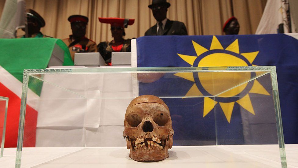 Members of a delegation from Namibia stand over 20 skulls from the Herero and Nama tribal groups at the conclusion of a ceremony at Charite hospital in Berlin, Germany to repatriate the skulls on 30 September 2011