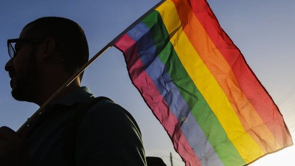 Man holding rainbow flag