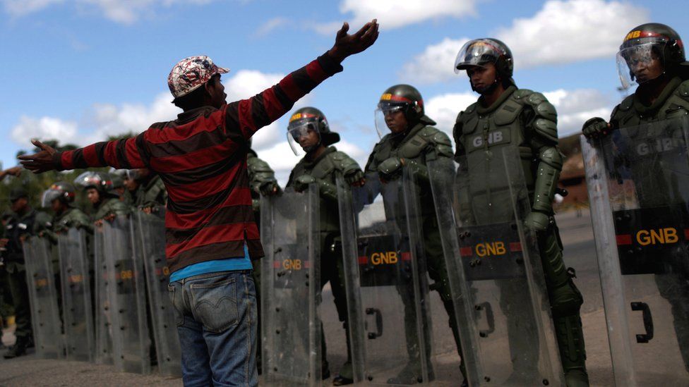 People approach Venezuelan troops at the border in the Brazilian city of Pacaraima, 22 February 2019