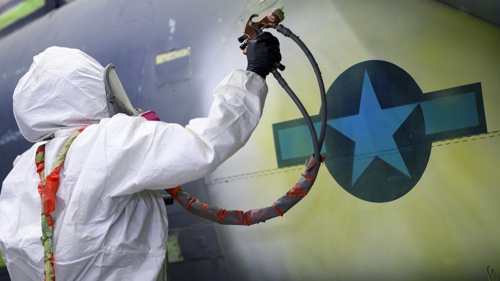 An airman based at RAF Lakenheath paints around a National Star insignia