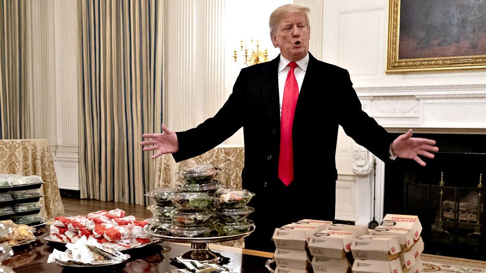 US President Donald Trump presents fast food to be served to the Clemson Tigers football team