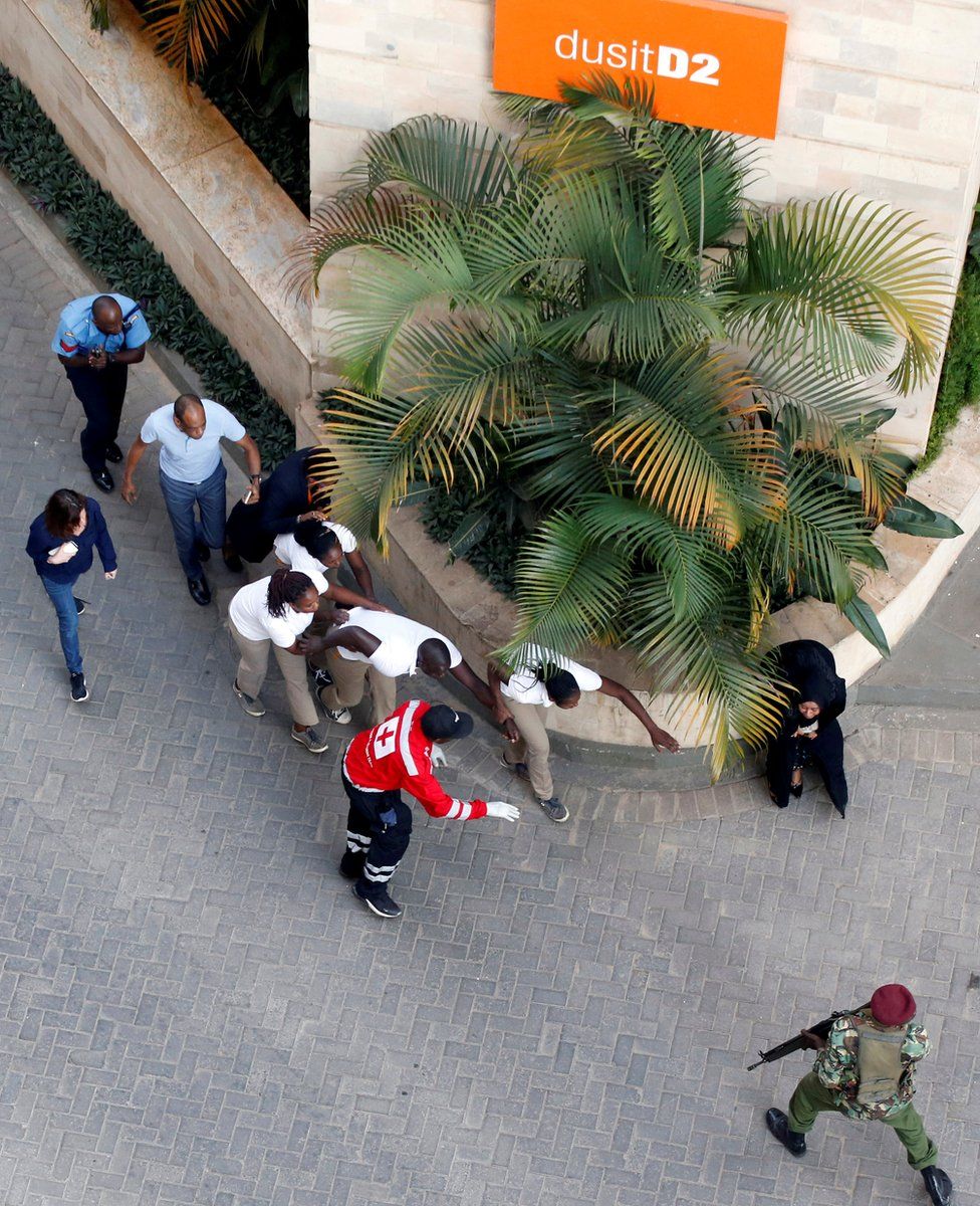 Aerial high angle shot people are evacuated at the scene where explosions and gunshots were heard at the Dusit hotel compound, in Nairobi