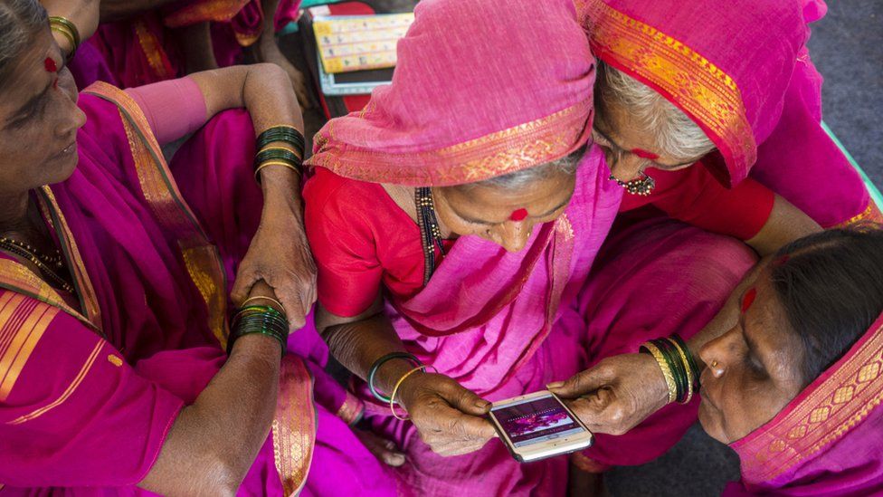 women checking a mobile phone together