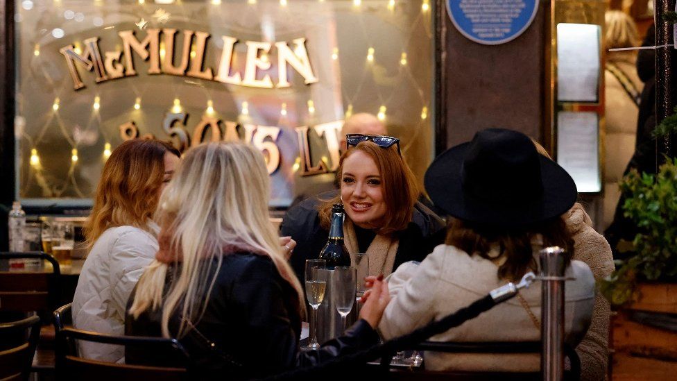 Customers enjoy drinks outside a pub in Covent Garden on the last Saturday for shopping before Christmas, in central London on December 18, 2021.