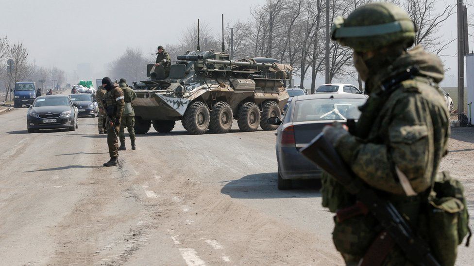 Service members of pro-Russian troops stand guard at a checkpoint in the course of Ukraine-Russia conflict in the besieged southern port city of Mariupol, Ukraine March 24