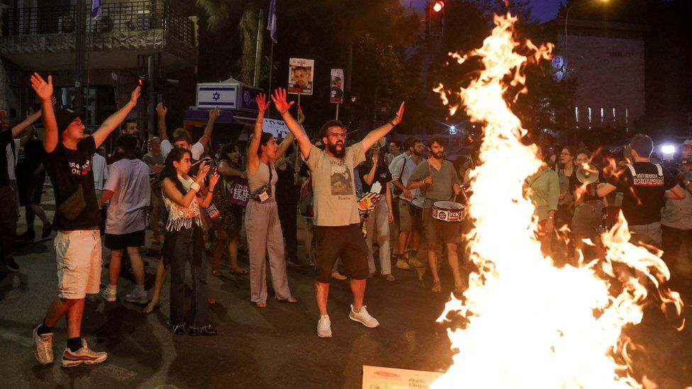 Protesters gesture around a bonfire as protesters attend a rally calling for the immediate release of Israeli hostages held in Gaza, near the Israeli prime minister's residence in Jerusalem (24 April 2024)