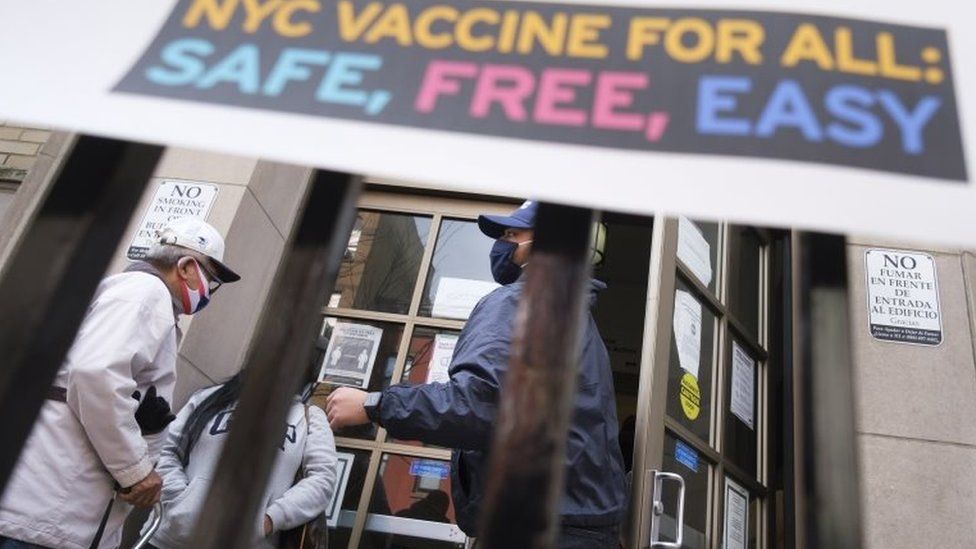 People enter a COVID-19 vaccine distribution site in New York