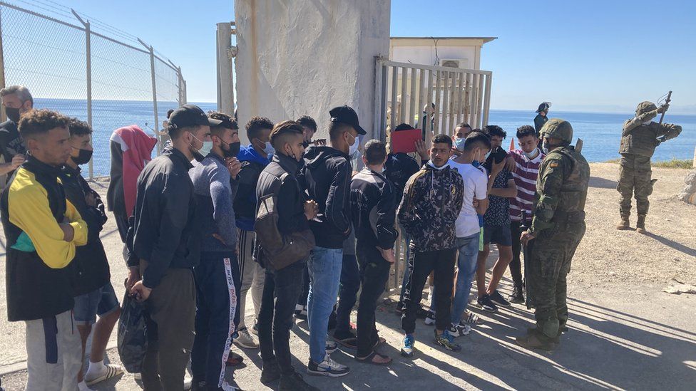 A group of men line up as they re-enter Morocco from Ceuta