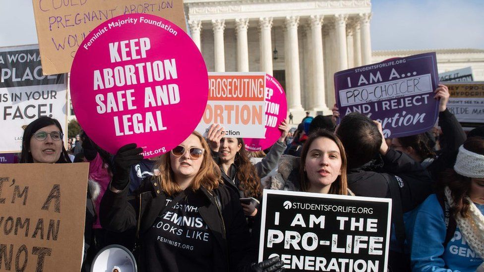 Pro-choice activists hold signs alongside anti-abortion activists participating in the "March for Life," an annual event to mark the anniversary of the 1973 Supreme Court case Roe v. Wade, which legalized abortion in the US, outside the US Supreme Court in Washington, DC