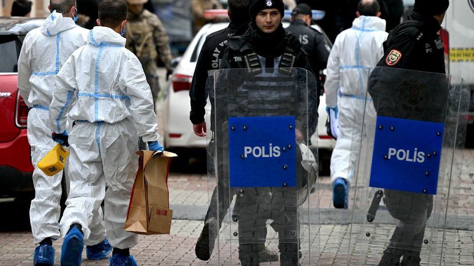 Turkish forensic police officers hold boxes as they walk in front of Santa Maria church after a attack, in Istanbul, on January 28, 2024.